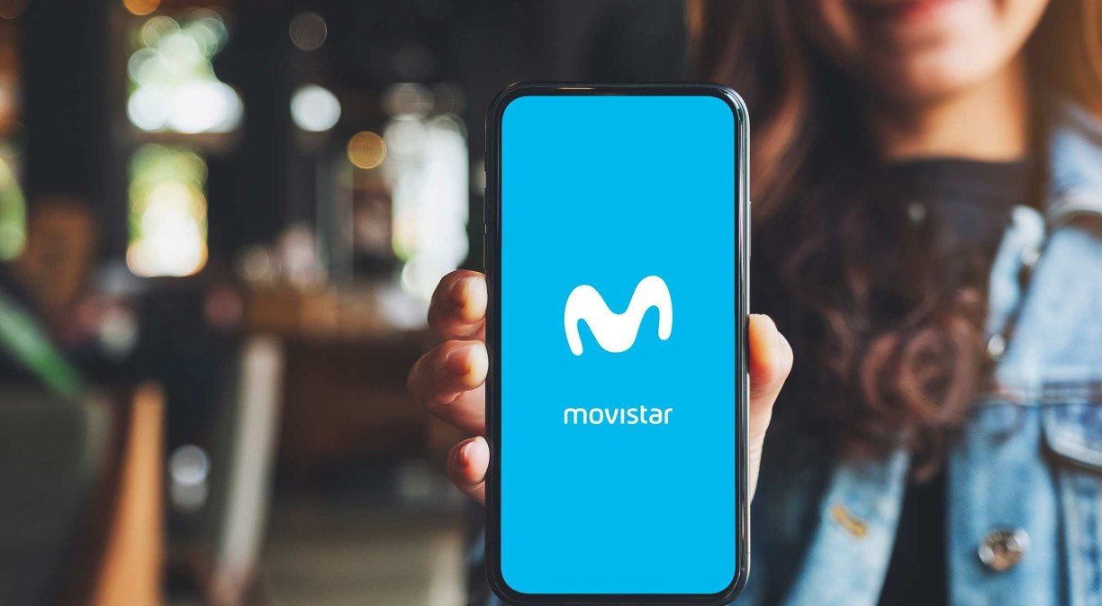 Una chica enseñando un móvil con el logo de Movistar